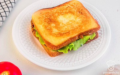 Готовый сэндвич разрежьте пополам и украсьте томатами черри и свежей зеленью.