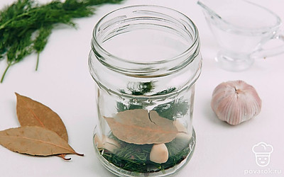 Промойте и обсушите укроп, выложите ее на дно банки, затем положите лавровый лист, чеснок и перец.