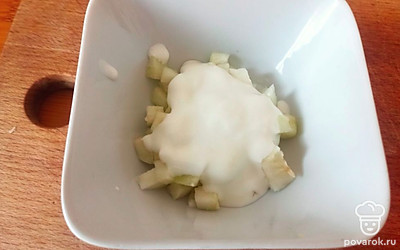 Ананасы порежьте на кубики и заправьте сметаной.