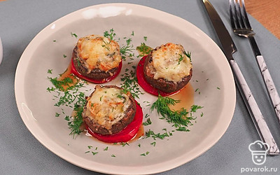 Запеченные в духовке фаршированные шампиньоны с сыром подавайте, посыпав зеленью укропа.