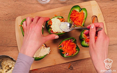 Нафаршируйте перцы и запеките в духовке. Смешайте сыр в миске с майонезом. В каждую половинку перца выложите фарш, затем морковь, а сверху — сыр с майонезом. Смажьте противень для запекания растительным маслом, выложите туда перцы и запекайте в течение 50 минут.