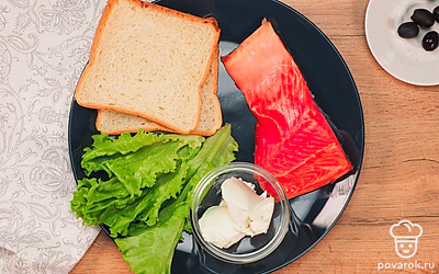 Подготовьте продукты. Заранее поджарьте в тостере или в духовке ломтики хлеба. Если вы поджариваете хлеб в духовке, не забывайте время от времени переворачивать его щипцами и следите, чтобы хлеб не пересушился и не превратился в сухарик. Вымойте и просушите листья салата. Нарежьте рыбу на слайсы толщиной до 5 мм.
