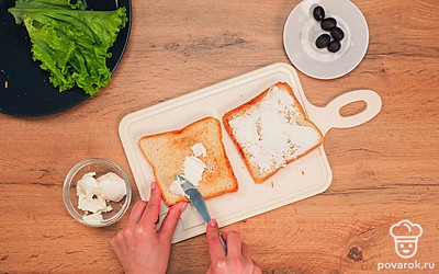 Намажьте каждый ломтик хлеба 1 столовой ложкой творожного сыра с одной стороны.