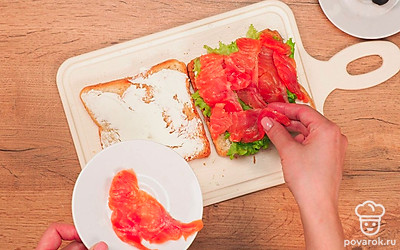 Соберите сэндвичи: на 2 ломтика хлеба поверх сыра выложите по листу салата, на салат – нарезанную рыбу, на рыбу – помидор, на помидор – снова лист салата. Накройте сэндвичи оставшимися ломтиками хлеба, которые вы до этого смазывали сыром.