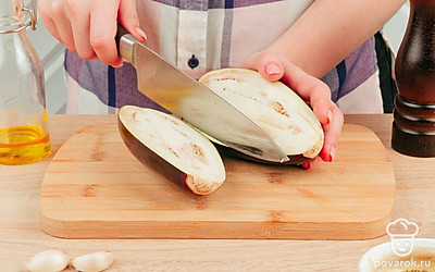 Разрежьте баклажан вдоль на 2 половинки и вырежьте мякоть в середине. Переложите половинки в емкость для запекания, посыпьте солью и оставьте на 20 минут, чтобы они не горчили. Затем промойте, обсушите, полейте растительным маслом и пока оставьте.