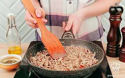 Поставьте на огонь глубокую сковороду (можно ту же, в которой жарились овощи), налейте немного масла и выложите фарш. Перемешивая его лопаткой и разбивая на мелкие кусочки, обжаривайте, пока мясо не изменит свой цвет с красного на коричневый.