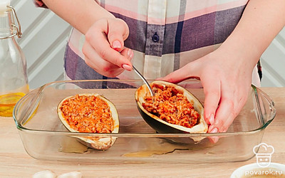 Дайте фаршу немного остыть, затем переложите его в баклажановые «тарелки». Утрамбуйте начинку ложкой, чтобы она заполнила всю полость.