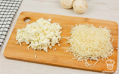 Аккуратно удалите ножки шампиньонов, не задевая шляпки. Натрите на терке брынзу и пармезан.