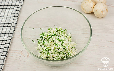 В отдельной емкости смешайте брынзу с измельченной зеленью и хорошо перемешайте. Получившейся начинкой наполните шляпки шампиньонов.