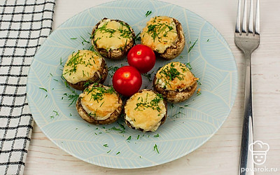 Готовые шампиньоны переложите на тарелку для подачи, украсьте свежей зеленью и помидорами черри.