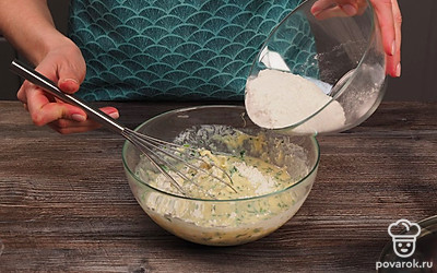 Приготовьте тесто. В миску налейте кефир, добавьте яйцо и щепотку соли (если сыр соленый, дополнительно соль не нужна), смешайте. Всыпьте сыр, зелень и перемешайте до однородности. Небольшими порциями, помешивая, всыпьте муку. После перемешивания должна получиться густая однородная масса.