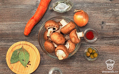 Простерилизуйте банки в духовом шкафу при температуре 120 ˚C 15 минут. Ставьте банки в холодную духовку. Крышки залейте кипятком. Стерелизовать емкости можно и другим способом. Выложите грибы в дуршлаг. Хорошо промойте их проточной водой. Вымойте морковь, очистите ее и натрите на крупной терке. Очистите лук. Промойте водой и нарежьте мелкими кубиками. Можно измельчить лук в блендере. Нарежьте оливки или маслины колечками. Подготовьте мясорубку.