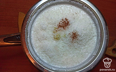 Затем, влейте кокосовое молоко, после закипания добавьте натертый на мелкой терке имбирный корень, специи и кокосовую стружку, перемешайте. Проварите кашу еще 7-10 минут и снимите с огня.