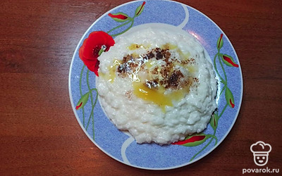 Подавайте рисовую кашу на кокосовом молоке с имбирем, в глубоких тарелках. По своему вкусу добавьте сливочное масло и мед. Украсьте блюдо кокосовыми хлопьями.