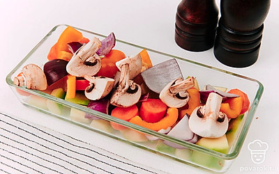 В форму для запекания выложите баклажаны, морковь, лук, грибы и перец. Посолите и поперчите по вкусу.