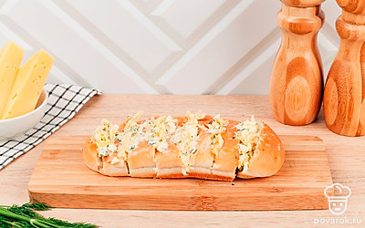 Сделайте надрезы поперек батона на расстоянии 2-3 см друг от друга. В разрезы выложите начинку.