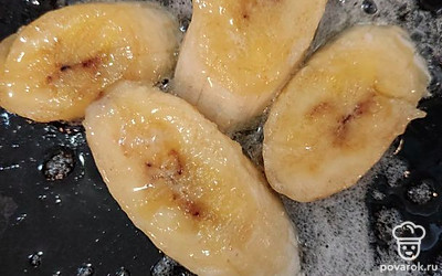 Масло растопить на сковороде, добавить оставшийся сахар и банан, порезанный на дольки. Обжарить по нескольку минут с каждой стороны.