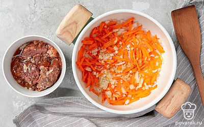 Приготовьте тушенку с овощами. В толстодонную кастрюлю выложите лук и морковь, добавьте растительное масло и тушите на среднем огне 5 минут. Добавьте к овощам тушенку и перемешайте. Готовьте еще пару минут.