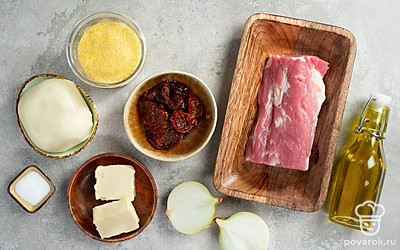 Промойте и просушите кукурузную крупу и початок кукурузы. Мякоть свинины помойте и обсушите бумажным полотенцем. Лук очистите от шелухи. Вяленые помидоры, если они в масле, извлеките из него, отложите 5 штук для украшения. Початок кукурузы отварите или запеките в духовке в течение 40 минут. Руколу помойте и просушите.