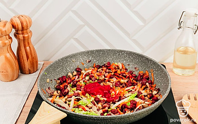 Добавьте в сковороду красную фасоль, пекинскую капусту и томатную пасту. Перемешайте. Готовьте еще немного до мягкости капусты.