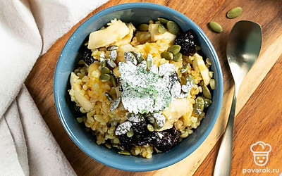 Каша из булгура с сухофруктами будет особенно аппетитно выглядеть, если украсить ее тыквенными семечками.