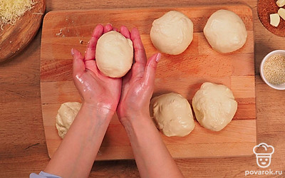 Приступите к разделке. Разделите тесто на кусочки, каждый весом примерно по 100 г (можно воспользоваться кухонными весами), скатайте из каждого колобок и оставьте для подъема на 10 минут.