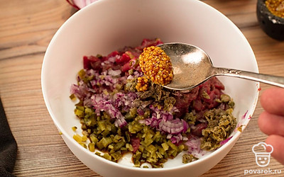 В миске смешайте мясо, горчицу, лук, корнишоны и каперсы.