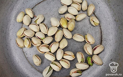 На сухой сковороде обжарьте фисташки. Почистите и измельчите их. Подготовленный манго разрежьте на две части. Половину порежьте мелкими кубиками и добавьте в кашу. Вторую половину используйте для украшения. Подготовленные фисташки, манго и кокосовую стружку отправьте в кастрюлю с кашей и перемешайте.