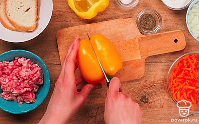 Промойте мясо и пропустите через мясорубку. Вымойте овощи, очистите лук и морковь, извлеките семена из перца. Мелко нарежьте лук, натрите морковь на терке. Разрежьте перцы пополам, если они крупные. Размочите хлеб в воде.