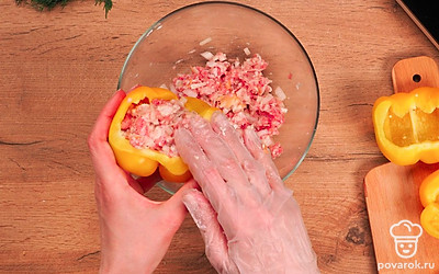 Приготовьте начинку и нафаршируйте перцы. В миску поместите мясной фарш. Лук добавьте к мясу вместе с размоченным хлебом. Посолите, поперчите и перемешайте. Перцы нафаршируйте начинкой.