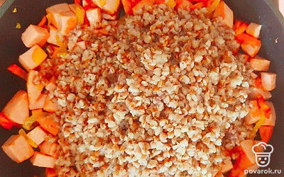 Высыпьте в сковороду к поджарке гречку, посолите, поперчите и перемешайте. После этого снимите с огня.