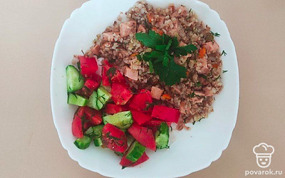 Гречку с колбасой подайте на тарелке, подчеркнув оранжевые кусочки моркови. Сверху положите украшение в виде веточки петрушки. Подайте салат из свежих овощей и соус на свое усмотрение.