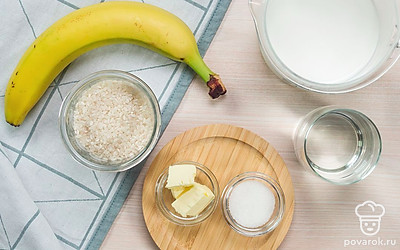 Подготовьте необходимые продукты для приготовления каши. Заранее достаньте молоко из холодильника, оно должно быть комнатной температуры. Банан вымойте, очистите от кожуры и нарежьте небольшими кубиками. Рис промойте и откиньте на дуршлаг.