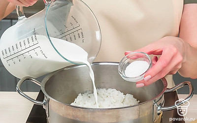 Добавьте оставшиеся продукты и завершите приготовление каши. Влейте в рис молоко, добавьте сахар, перемешайте и варите на медленном огне до готовности приблизительно 15 минут. Затем добавьте кусочки банана и перемешайте.