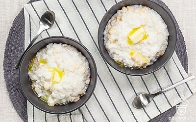 Разложите рисовую кашу по порционным тарелкам, в каждую добавьте по небольшому кусочку сливочного масла.