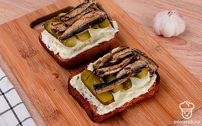 Сверху выложите яйца, огурцы и шпроты.