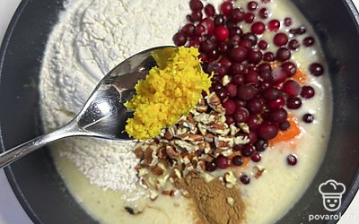 Добавить оставшиеся ингредиенты для теста: муку с разрыхлителем, соль, цедру апельсина, морковное пюре, ванильный экстракт (по желанию), специи, клюкву, а также орехи макадамия или грецкие, предварительно мелко нарезанные.