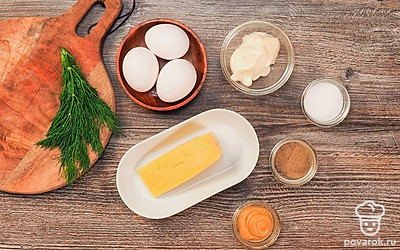 Вымойте яйца, сварите вкрутую, остудите и очистите от скорлупы. Вымойте укроп и мелко нарежьте. Сыр натрите на средней терке. Подготовьте противень. Включите духовку на 150 градусов.