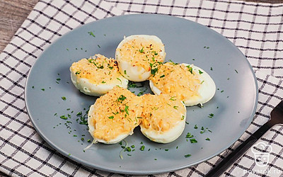 Фаршированные яйца выложите на сервировочное блюдо, сверху посыпьте зеленью укропа.