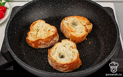 Разогрейте сухую сковороду и подсушите на ней ломтики багета по 2 минуты с каждой стороны.