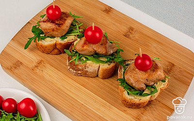 В брускетты воткните зубочистки или шпажки и украсьте помидорами черри.