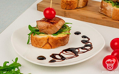 Готовые брускетты выложите на тарелку и сбрызните крем-бальзамиком.