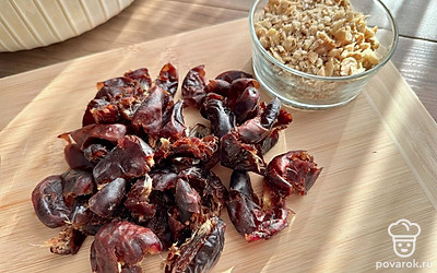 Грецкие орехи порубите ножом на крупные кусочки, из фиников достаньте косточку, разделите их на пару частей. 
