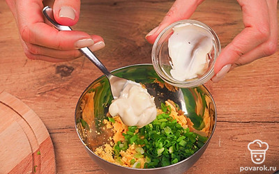 Подготовьте начинку. Разрежьте вареные яйца вдоль пополам. Выньте желтки, выложите их в миску, разомните. Зеленый лук добавьте к желткам. Заправьте майонезом и перемешайте. Если мало соли, посолите.