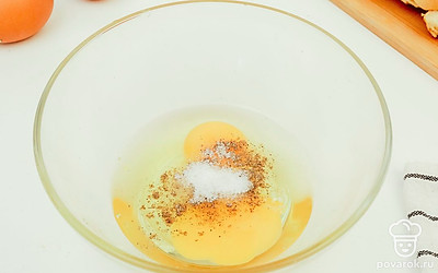 Разбейте яйцо, добавьте соль с перцем и перемешайте до однородного состояния.