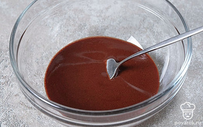 Достаньте из микроволновки растопленное масло. Всыпьте в него какао-порошок, а затем хорошо перемешайте массу. 