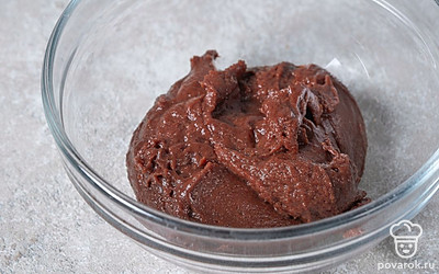 Всыпьте в миску столовую ложку муки и замесите тесто. Добавьте 1/3 тертого шоколада и оставшуюся муку. Хорошо перемешайте массу, чтобы не осталось мучных комочков. 