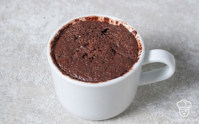 Поставьте кружку в микроволновку. Установите мощность 800 Вт и выпекайте кекс в течение 1,5 минуты. 