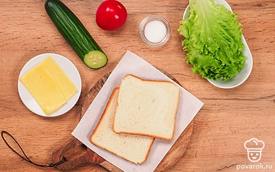 Расположите удобно все ингредиенты. Помойте помидор и огурцы. Помидоры нарежте кружочками, огурцы нарежте слайсами. Нарежьте тонкими ломтиками сыр. Подготовьте сковороду и столовые приборы.