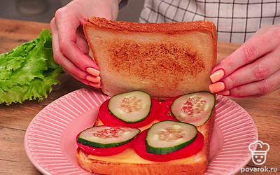 Соберите сэндвич. Для этого возьмите 1 ломтик хлеба, положите на него кусочки сыра, немного подсоленного помидора и свежий огурец. Сверху положите второй ломтик хлеба.